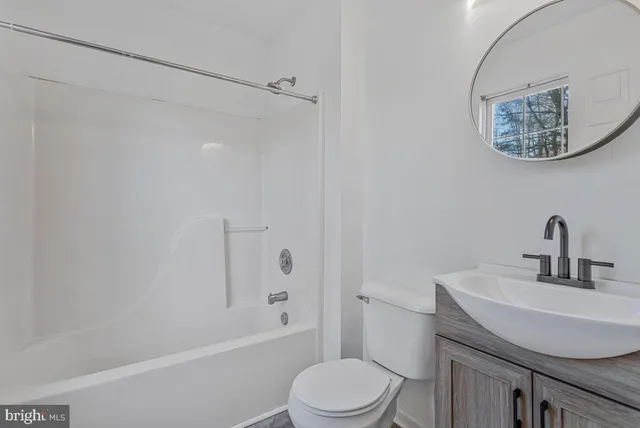 a bathroom with a granite countertop toilet a sink and a bathtub