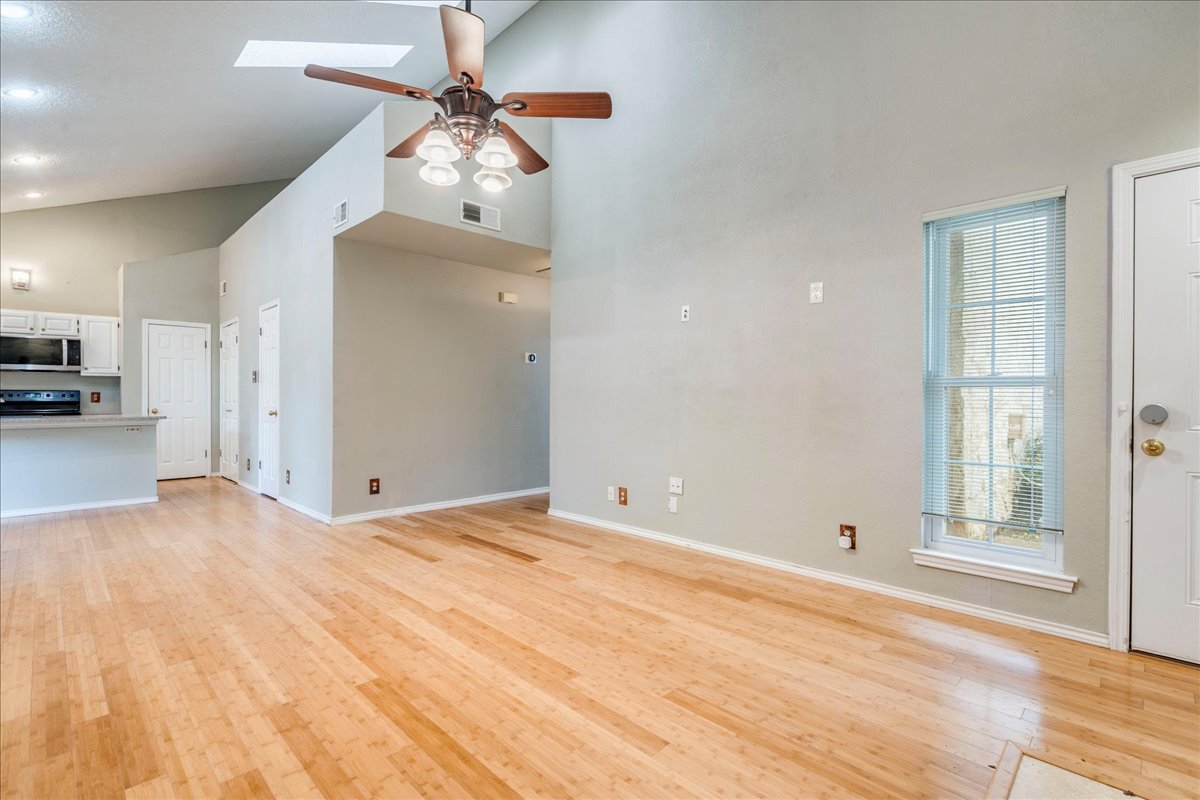 3809 Spicewood Springs Road, Unit 127 Austin, TX 78759 - Photo 4 of 29 Natural wood flooring complements soaring vaulted ceilings in this airy living space.
