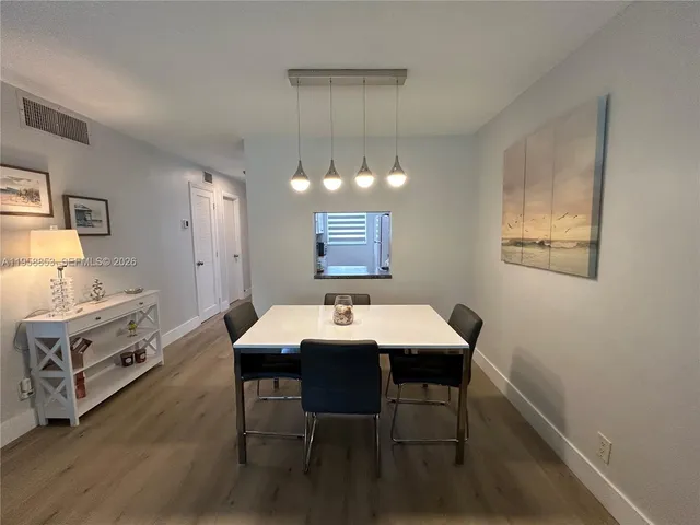 a view of a dining room with furniture a chandelier and wooden floor