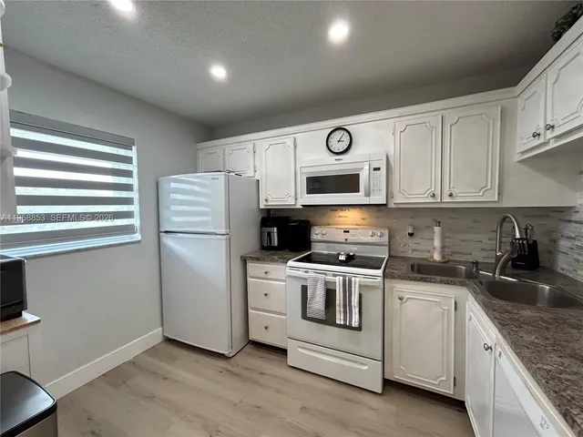a kitchen with a refrigerator stove and sink