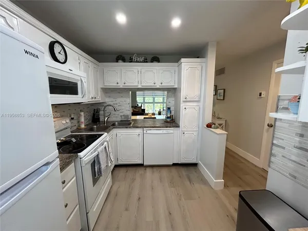 a kitchen with a sink a stove top oven and cabinets
