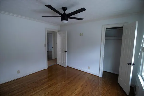 an empty room to hallway with wooden floor
