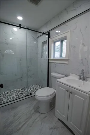 a bathroom with a shower a toilet and a window