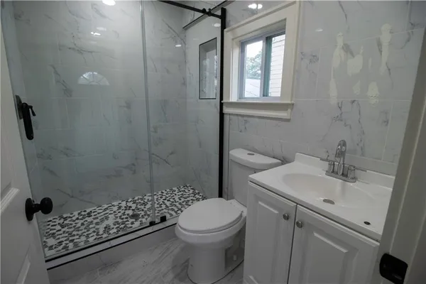a bathroom with a shower toilet and sink