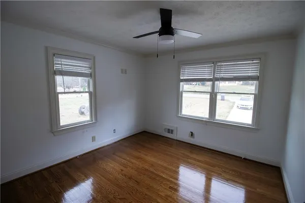 a view of a room with wooden floor and ceiling fan
