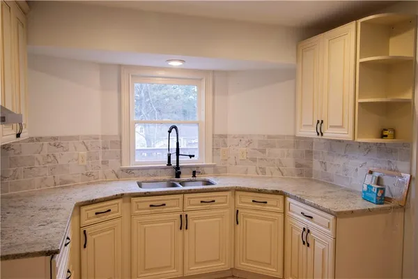 a view of a sink dishwasher and cabinets with wooden floor