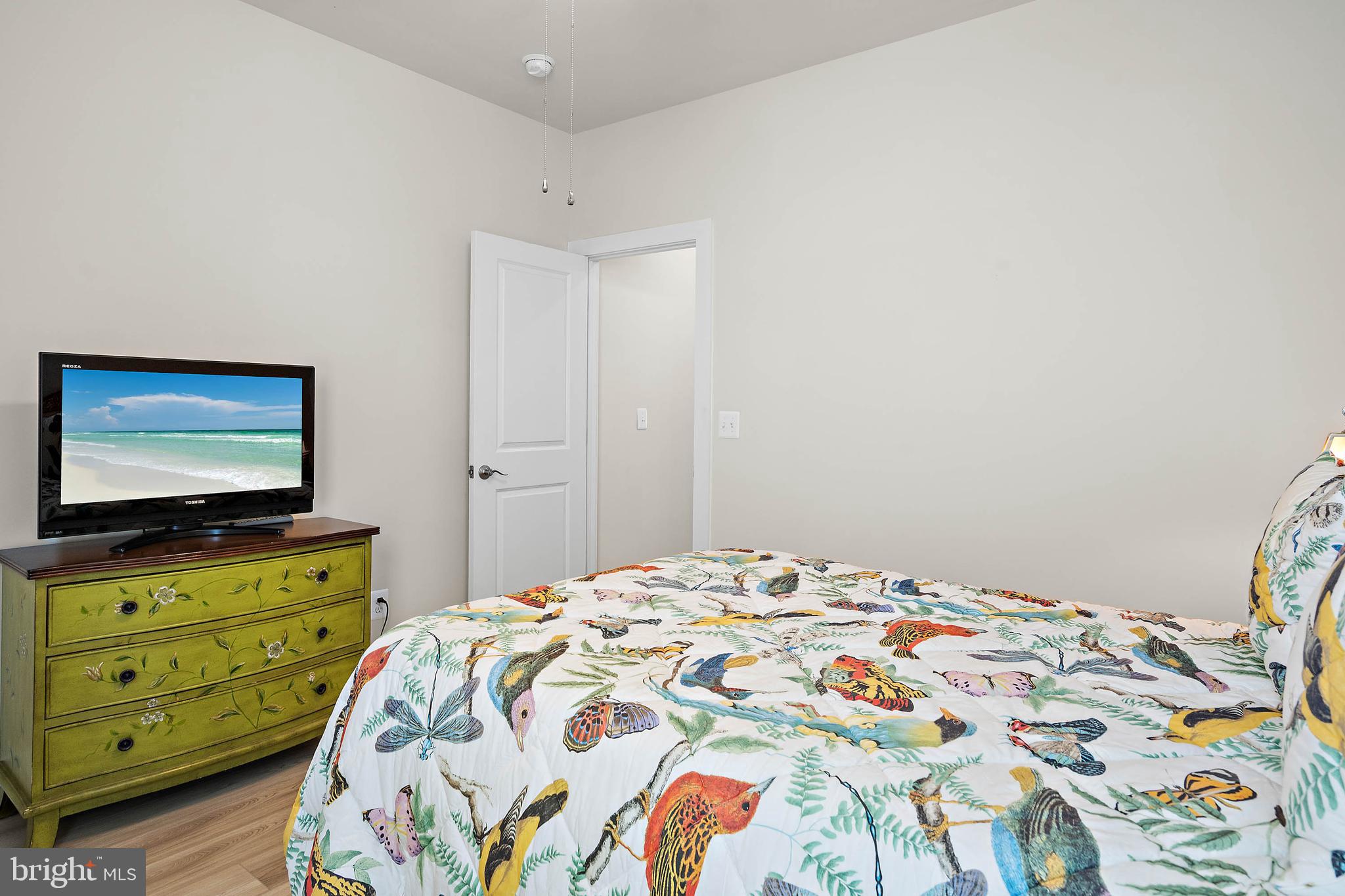 18565 Emerson Way Georgetown, DE 19947 - Photo 40 of 60 a bedroom with a bed and a flat tv screen on dresser