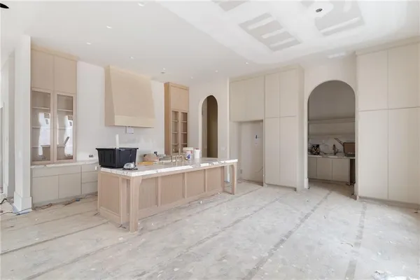 a large white kitchen with a sink and cabinets