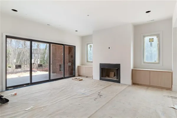 a view of an empty room with a fireplace and a window