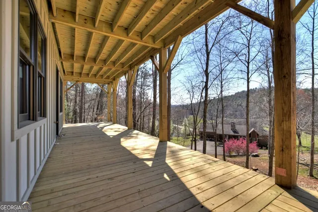 a view of a balcony with chairs and wooden floor