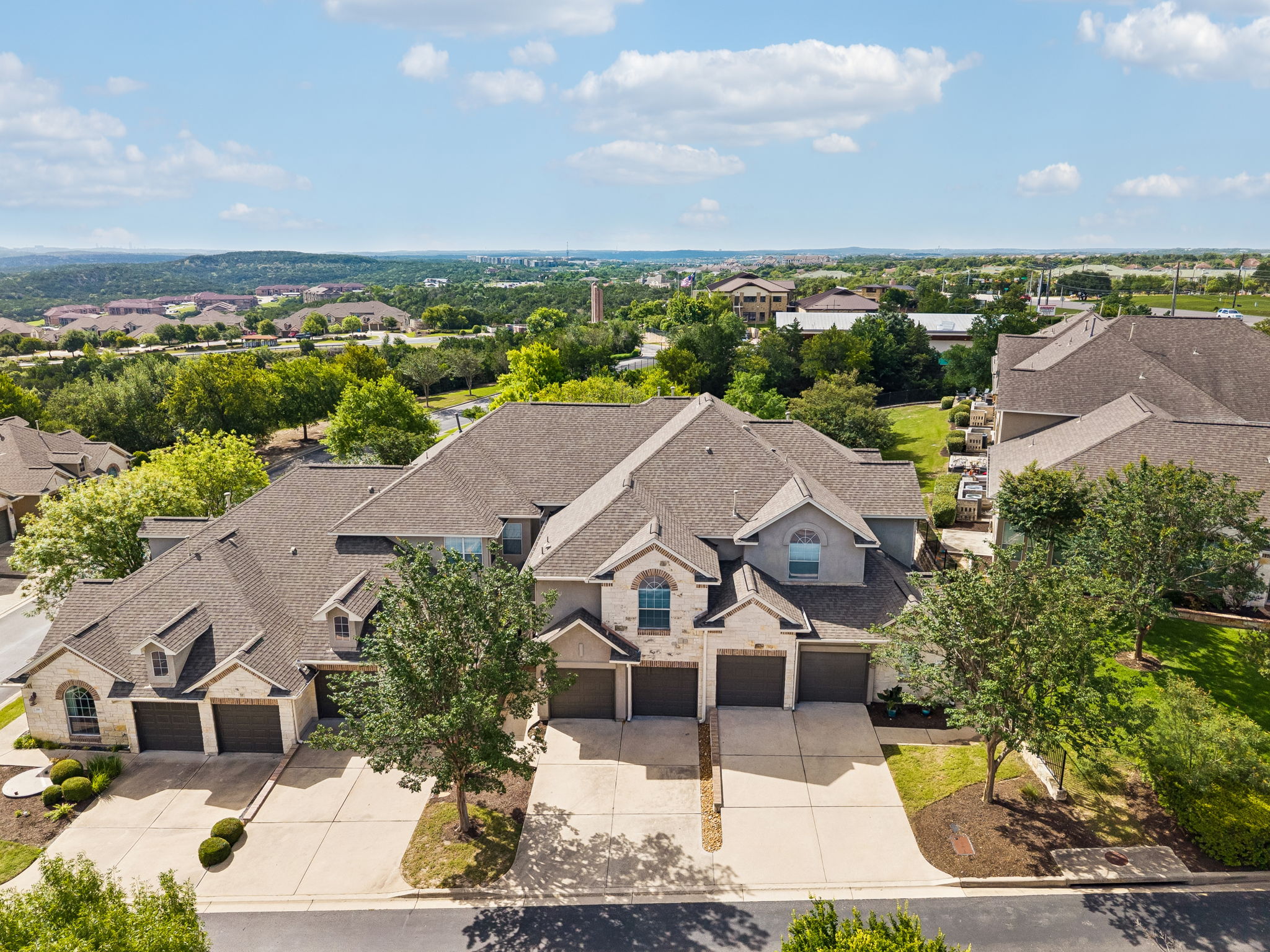 114 Aria Ridge, Unit 802 Lakeway, TX 78738 - Photo 34 of 37 An aerial perspective reveals a residential community nestled among rolling hills and verdant trees.