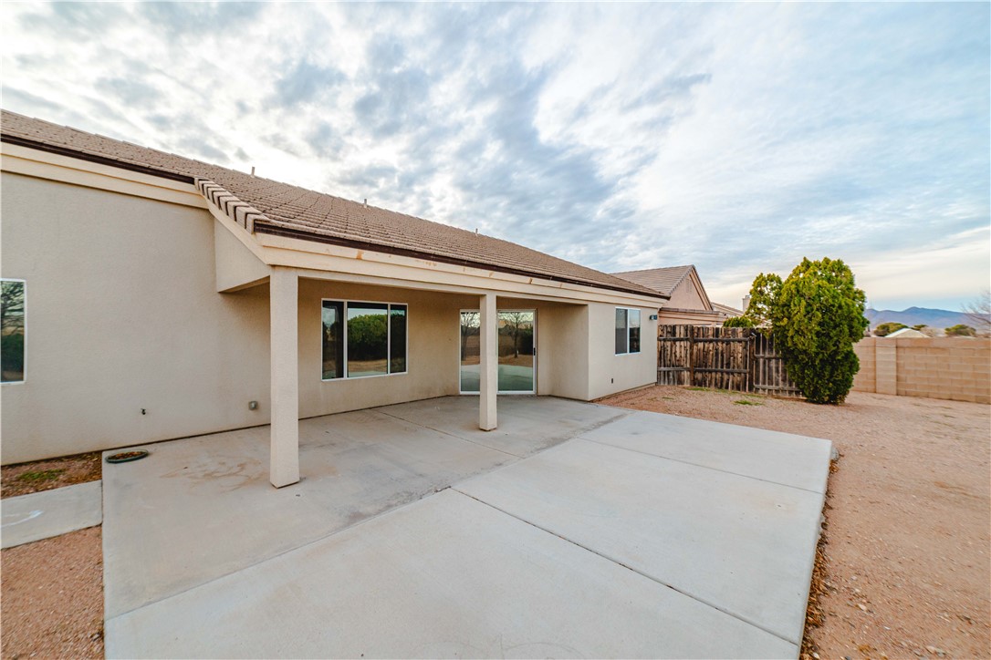 3374 Roma Road Kingman, AZ 86401 - Photo 56 of 64 Back of house with stucco siding, a patio area, and a fenced backyard