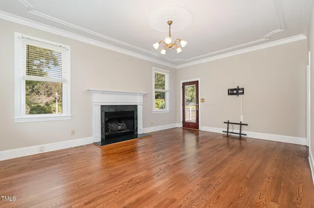 a dining room with chandelier and wooden floor