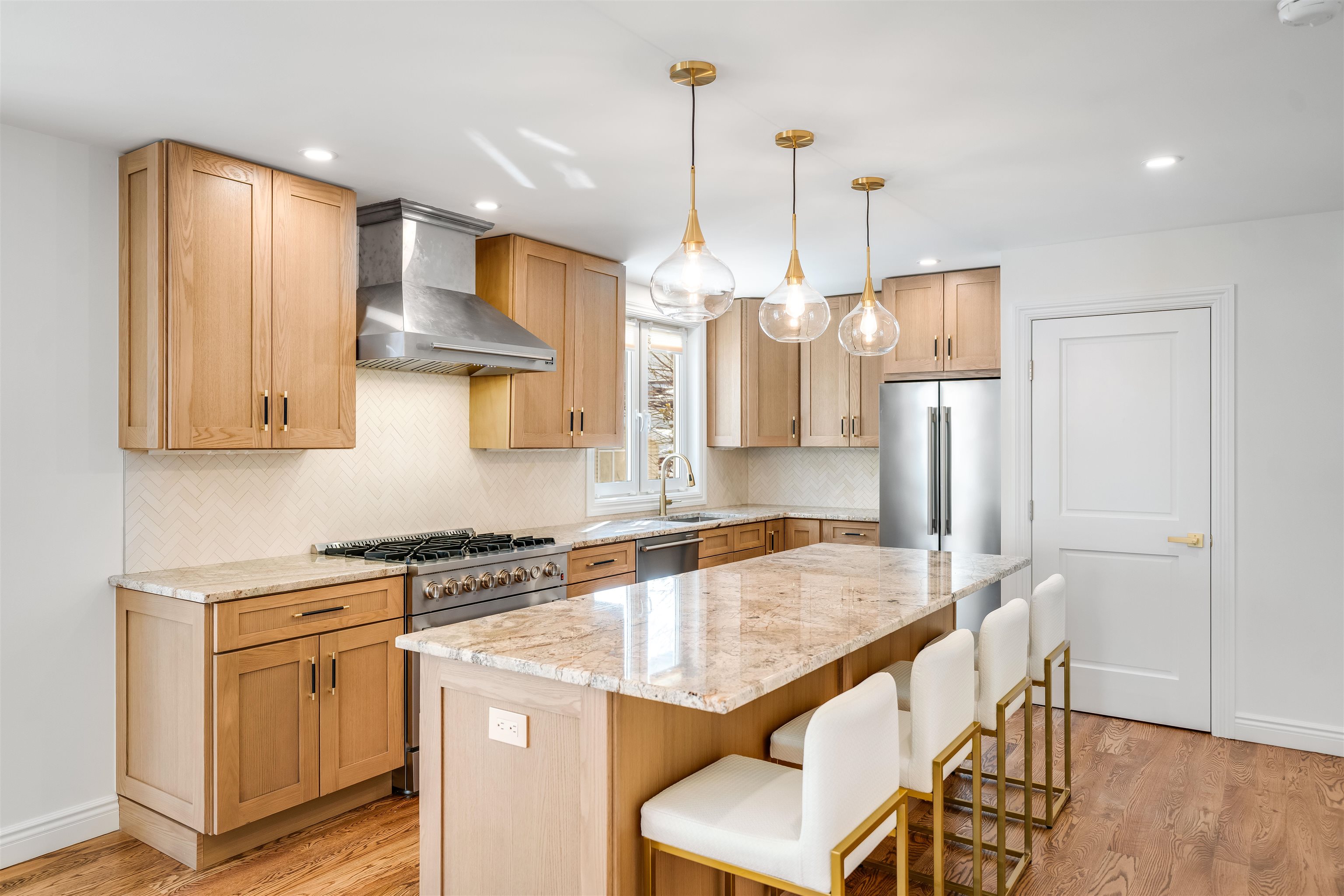 a kitchen with stainless steel appliances granite countertop a sink a stove and a refrigerator