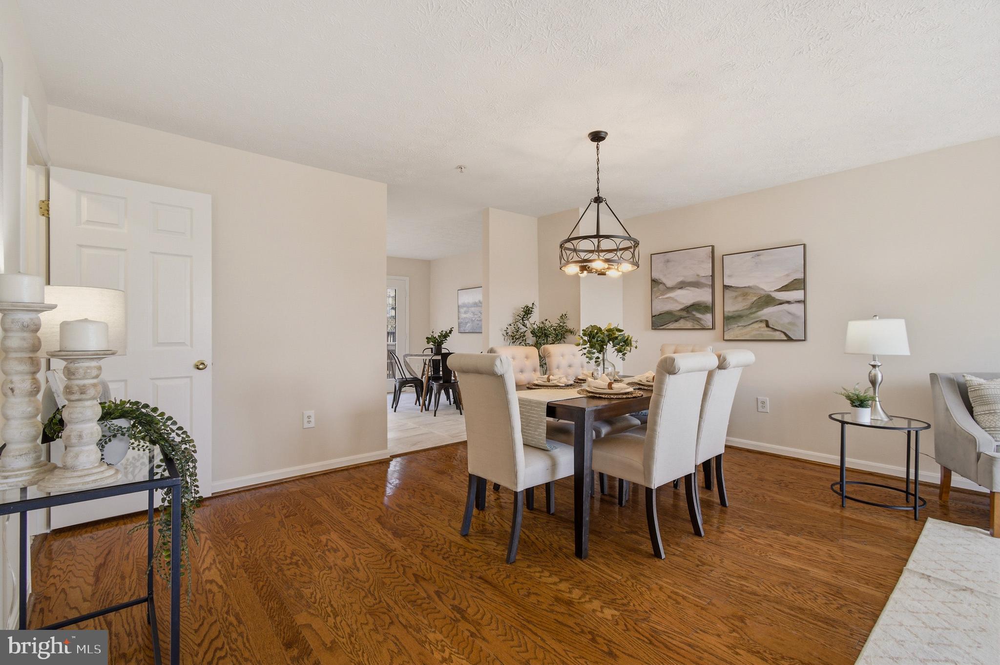 9054 Constant Course Columbia, MD 21046 - Photo 17 of 61 a dining room with furniture a chandelier and wooden floor