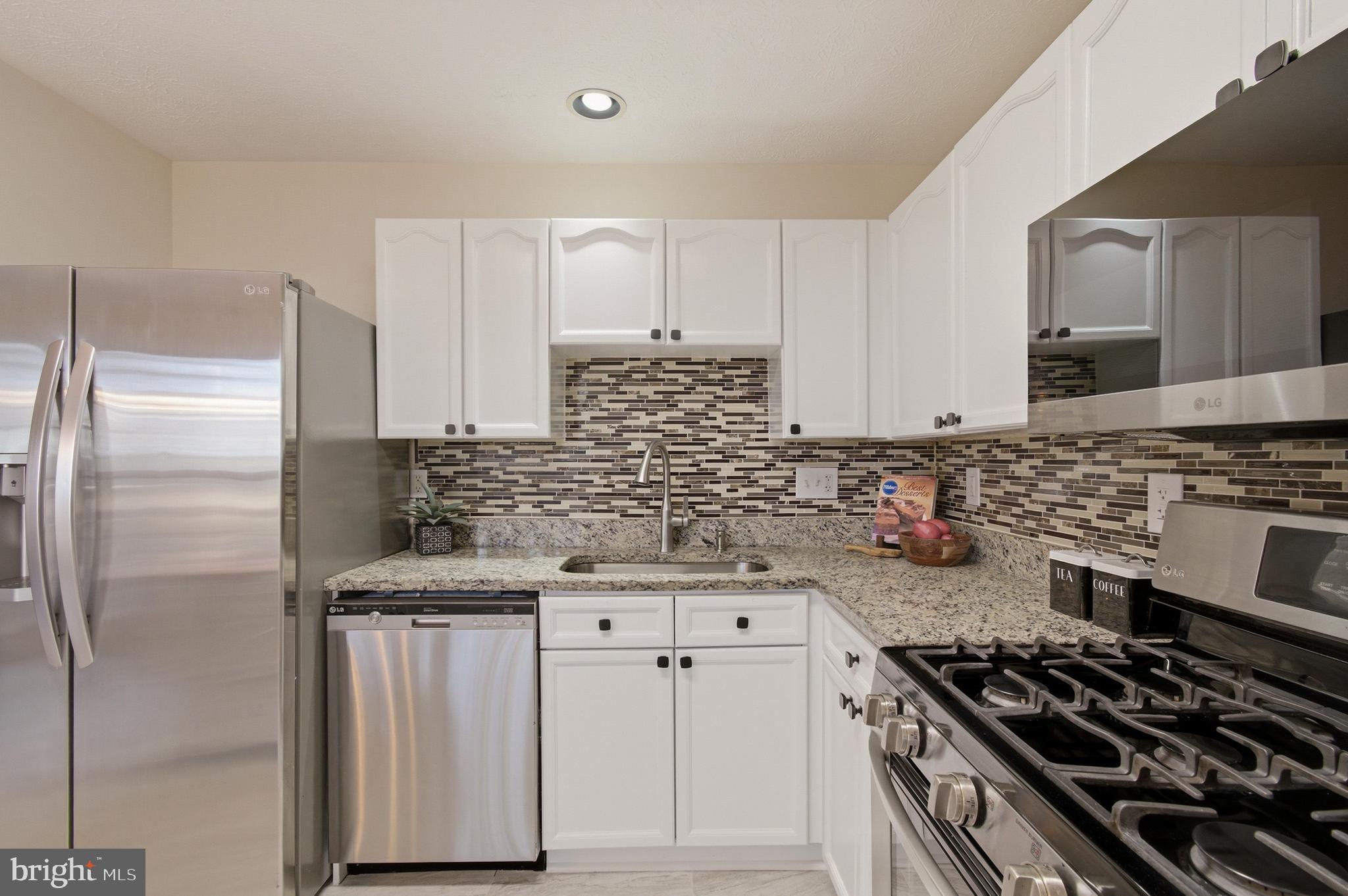 9054 Constant Course Columbia, MD 21046 - Photo 32 of 61 a kitchen with granite countertop a stove sink and cabinets