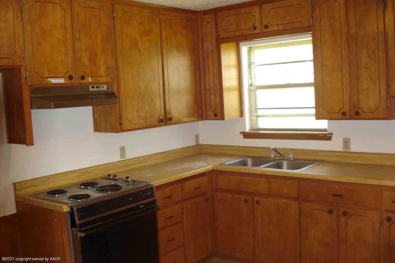 4202 Cline Road Amarillo, TX 79110 - Photo 3 of 7 a kitchen with a sink stove and cabinets