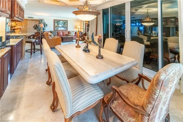 a kitchen with stainless steel appliances granite countertop a refrigerator a stove and a dining table with wooden floor