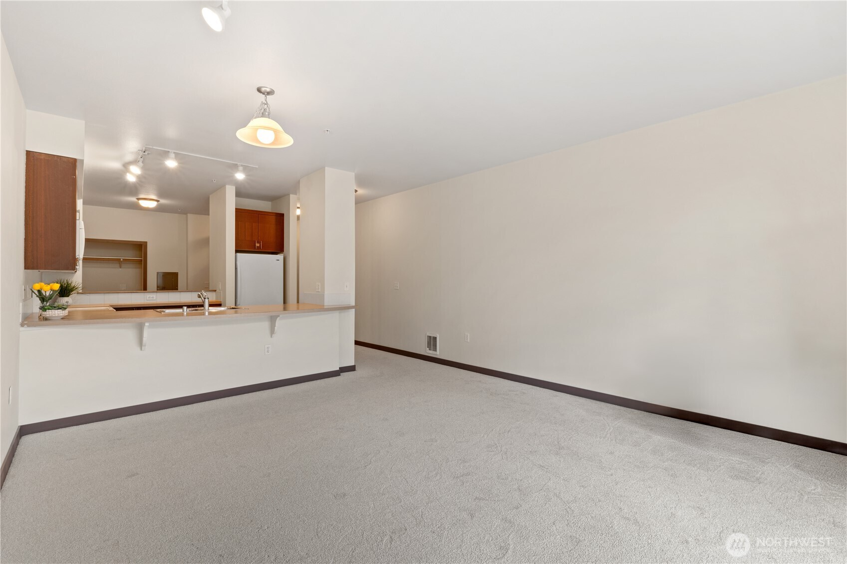 910 Gladstone Street, Unit 103 Bellingham, WA 98229 - Photo 6 of 28 an empty room with kitchen view and wooden floor