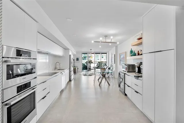 a view of a kitchen with furniture and a refrigerator