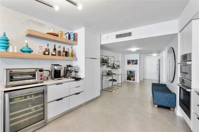 a living room with furniture a large window and potted plants