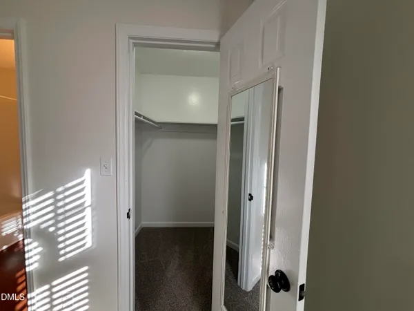 a view of a hallway with wooden floor and glass door