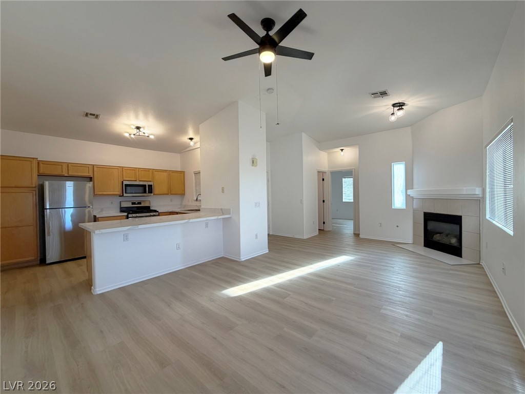 8725 West Flamingo Road, Unit 226 Las Vegas, NV 89147 - Photo 11 of 11 Kitchen featuring open floor plan, stainless steel appliances, light countertops, ceiling fan, and light wood-style flooring