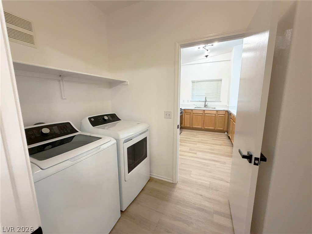 8725 West Flamingo Road, Unit 226 Las Vegas, NV 89147 - Photo 5 of 11 Laundry area with light wood-style floors and independent washer and dryer