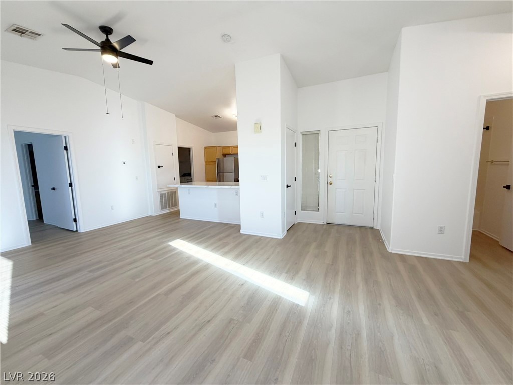 8725 West Flamingo Road, Unit 226 Las Vegas, NV 89147 - Photo 6 of 11 Unfurnished living room featuring light wood-style flooring, a ceiling fan, and lofted ceiling