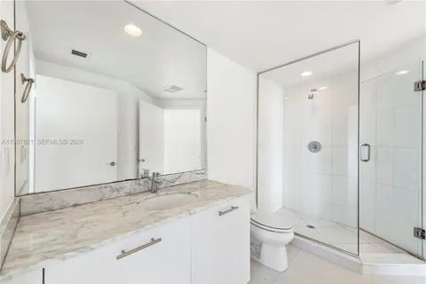 a bathroom with a granite countertop sink a toilet and shower