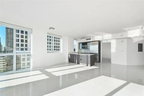 a living room with stainless steel appliances kitchen island a large window in the middle