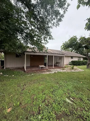 a backyard of a house with table and chairs