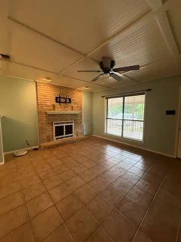 a view of an empty room with a fireplace and a window