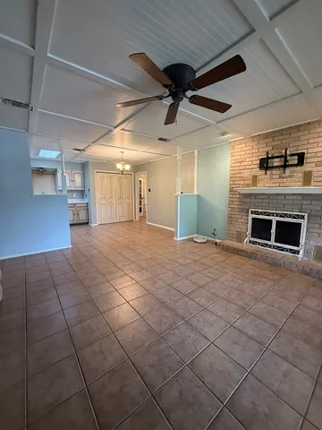 a view of an empty room with a fireplace and a window