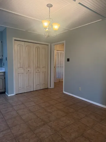 an empty room with chandelier fan