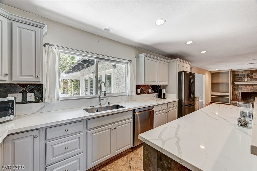 4153 Woodcrest Road Las Vegas, NV 89121 - Photo 17 of 58 Culinary delights await in this bright kitchen with premium finishes and a view of the outdoors.