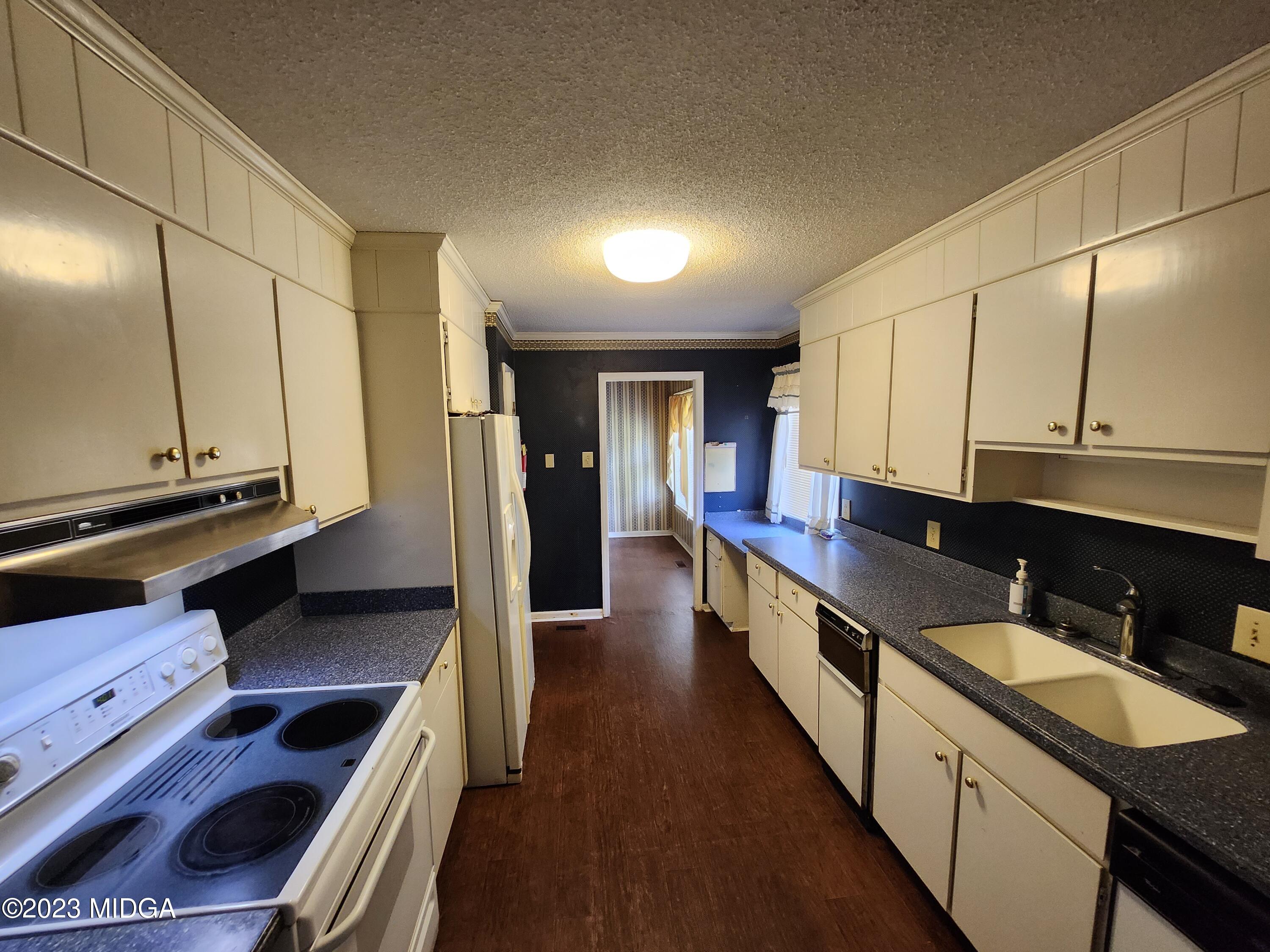 7338 Columbus Road Lizella, GA 31052 - Photo 17 of 33 a kitchen with counter top space and wooden floor
