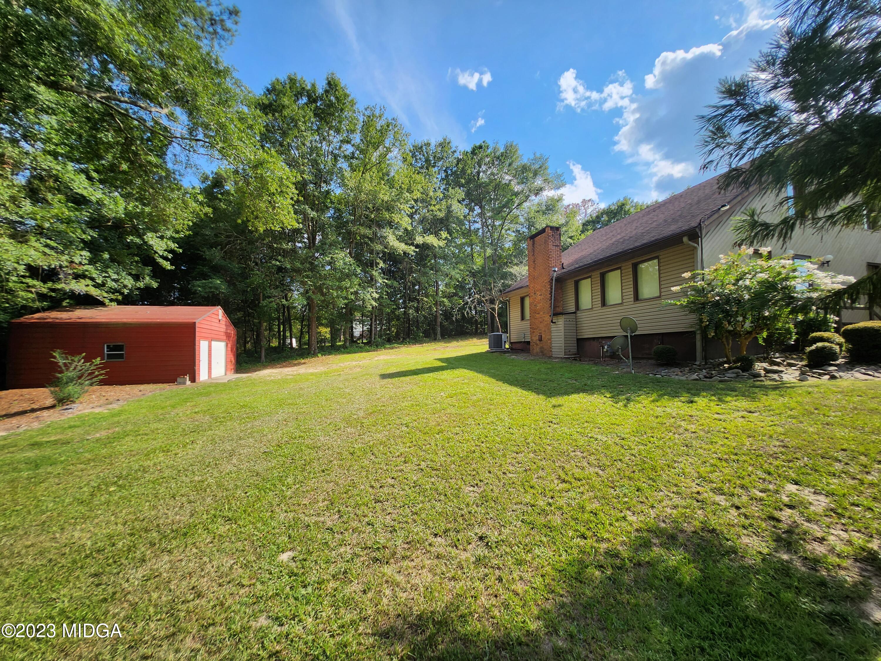 7338 Columbus Road Lizella, GA 31052 - Photo 4 of 33 a backyard of a house with lots of green space