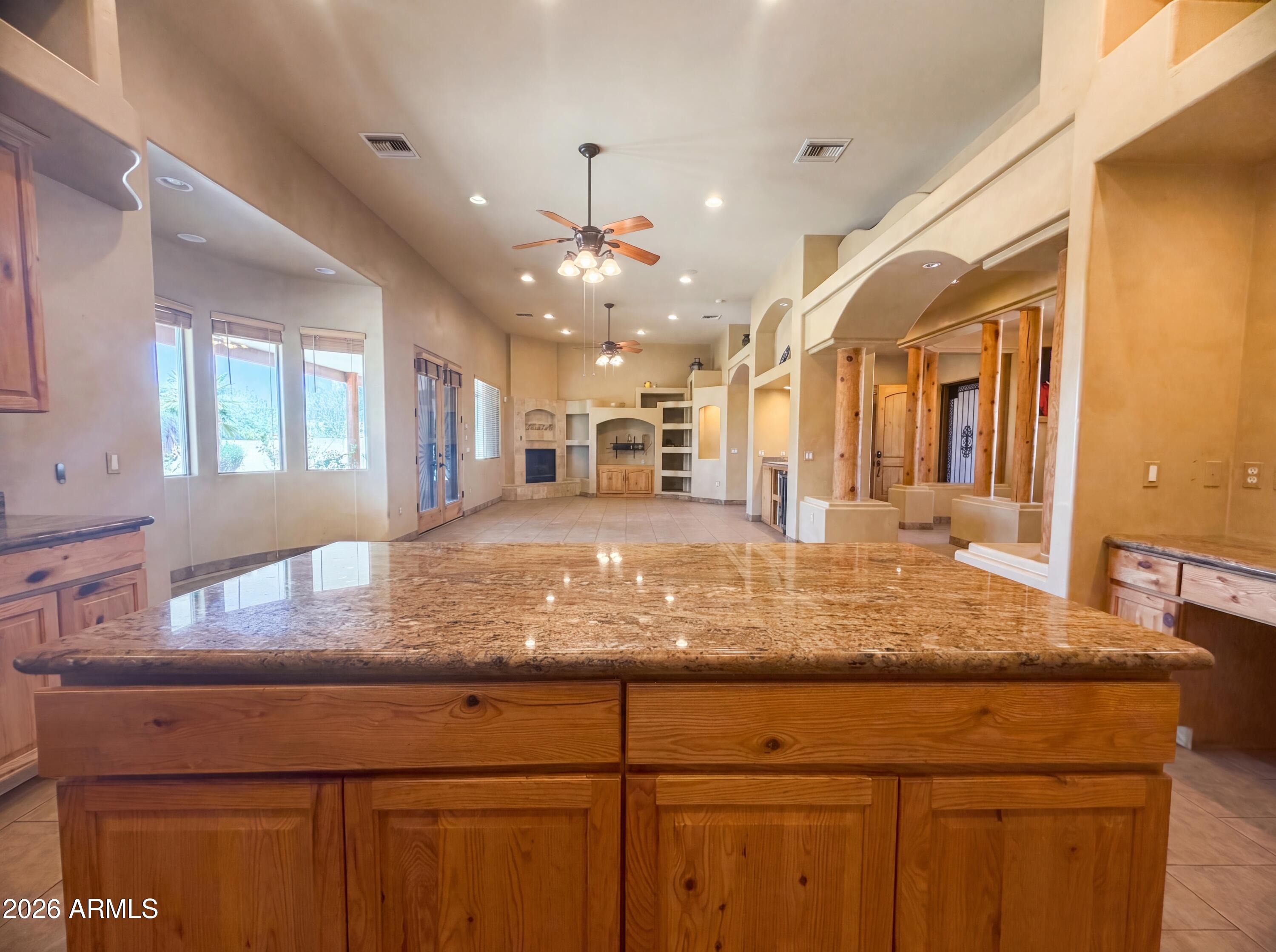 4496 South Kings Ranch Road Gold Canyon, AZ 85118 - Photo 6 of 22 a view of a kitchen with kitchen island a counter top space appliances and a chandelier