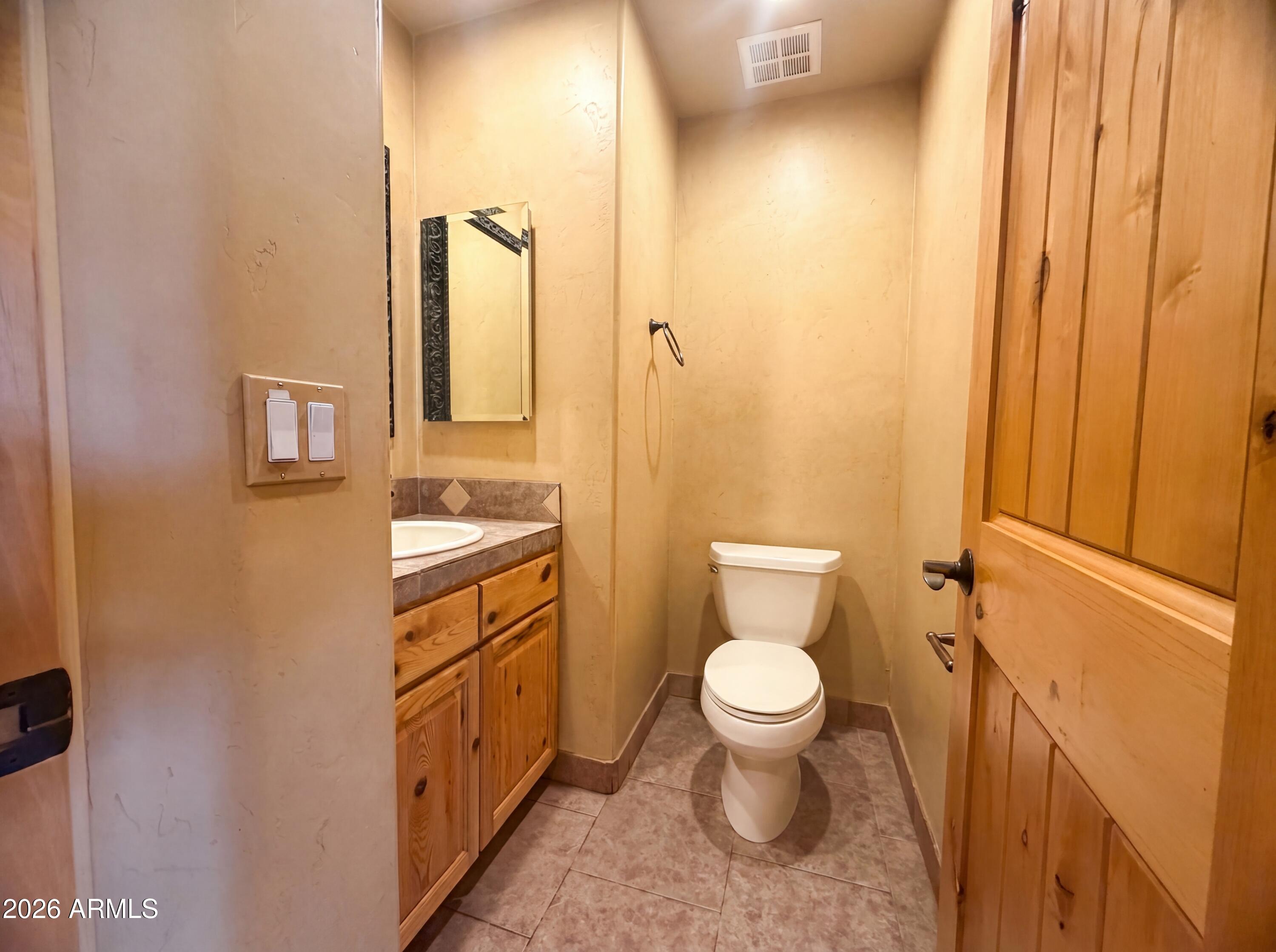 4496 South Kings Ranch Road Gold Canyon, AZ 85118 - Photo 10 of 22 a bathroom with a sink a toilet and a mirror