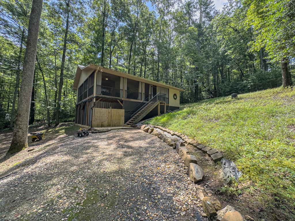 89 Box Turtle Lane Murphy, NC 28906 - Photo 2 of 51 a backyard of a house with large trees and stairs