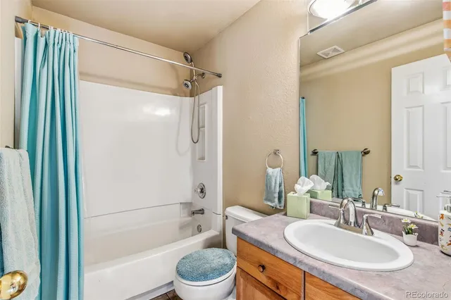 a bathroom with a granite countertop sink a mirror a bathtub and a shower