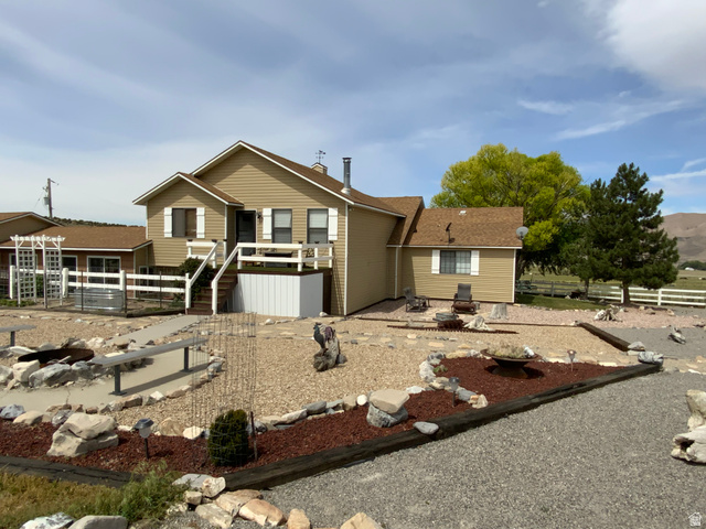 1061 Copper Street Stockton, UT 84071 - Photo 35 of 43 Exterior with tan siding, white window shutters, and a brown shingled roof