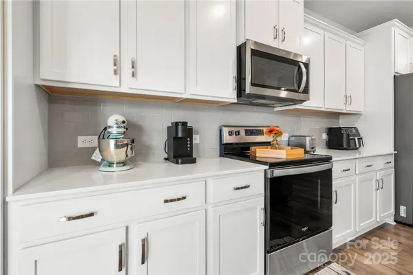 a kitchen with stainless steel appliances granite countertop white cabinets a sink and dishwasher