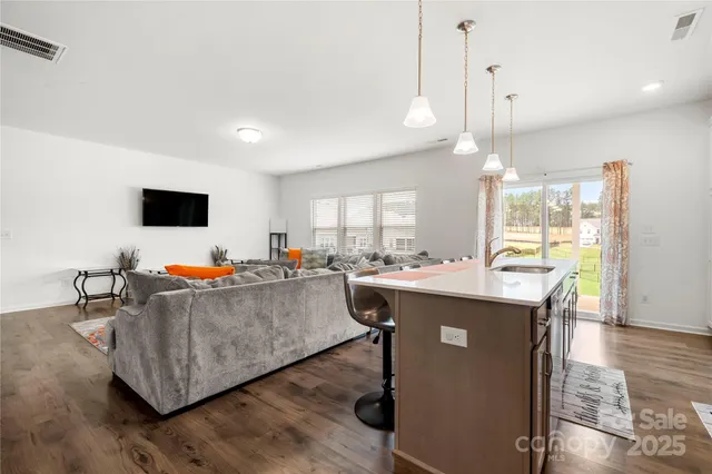 a living room with a table chairs and a flat screen tv