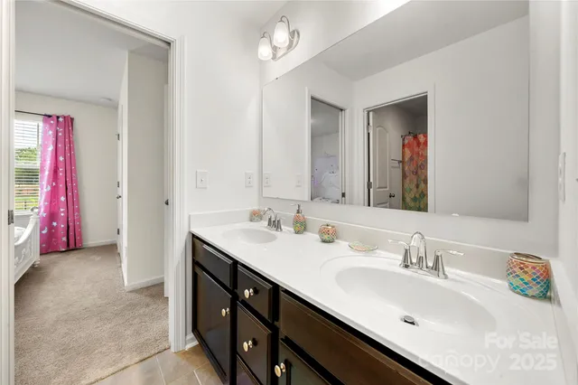 a en suite bathroom with a double vanity sink and a mirror