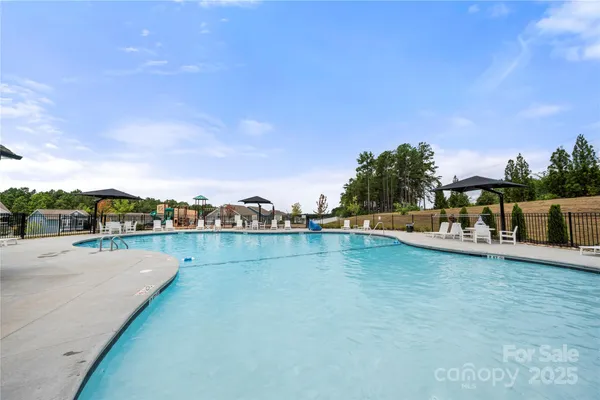 a view of a swimming pool with lawn chairs