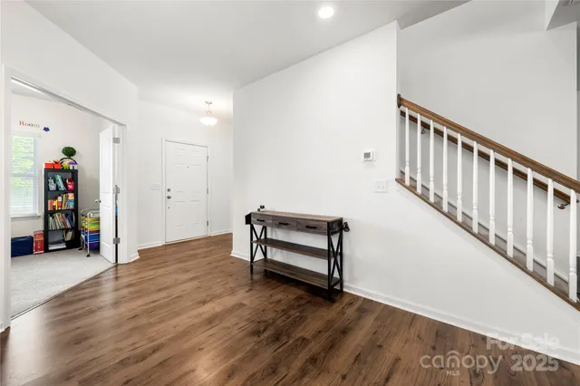a view of an empty room with stairs and a window