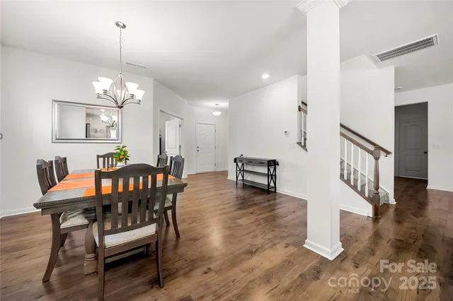 a dining room with furniture a chandelier and wooden floor