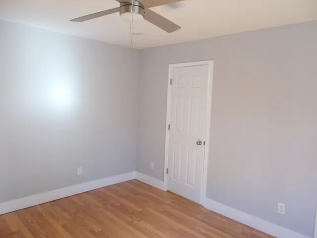a view of an empty room with wooden floor